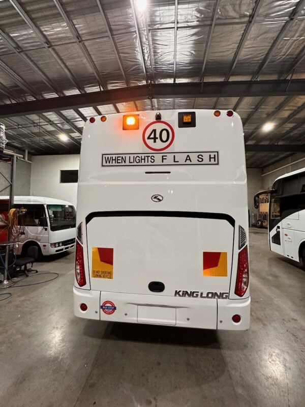 Photo of the rear of a 2024 King Long bus with Safebus SB001A surface mount New South Wales TS150 school bus lights and signage installed