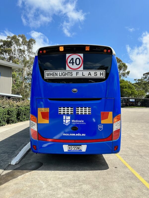 Photo of the rear of a 2024 Yutong D9 bus with Safebus SB001A surface mount New South Wales TS150 school bus lights and signage installed