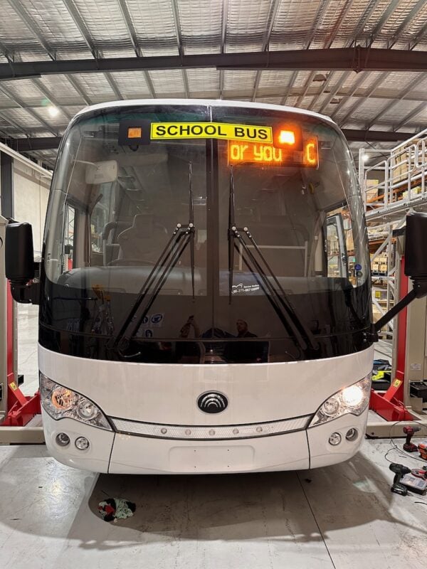 Photo of the front of a Yutong bus with Safebus SB001B window mount school bus wig-wag lights and NSW TS150 signage installed