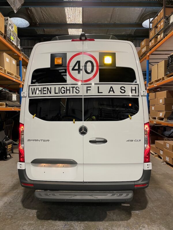 Photo of the rear of a 2024 Mercedes Sprinter bus with Safebus SB001A surface mount New South Wales TS150 school bus lights and signage installed