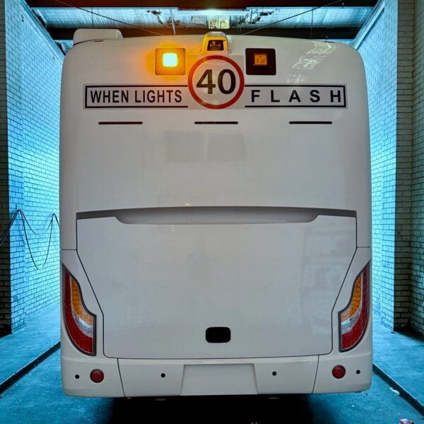 Photo of the rear of a Challenger bus with Safebus SB001A surface mount school bus lights and NSW TS150 signage installed