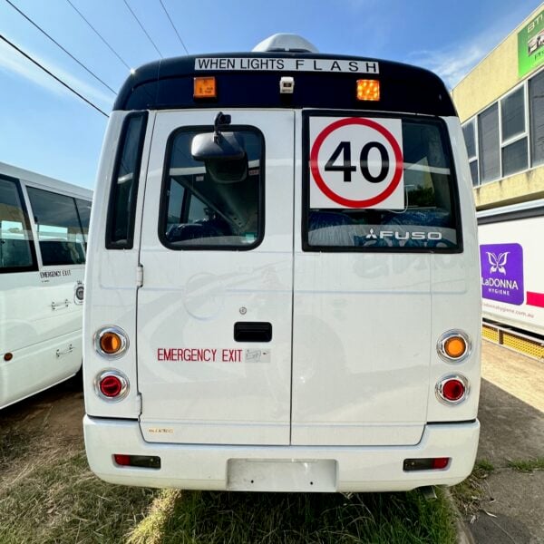 Photo of the rear of a Mitsubishi Rosa bus with NSW TS150 school bus lights and small 40km/h signage and Small When Lights Flash Signage installed