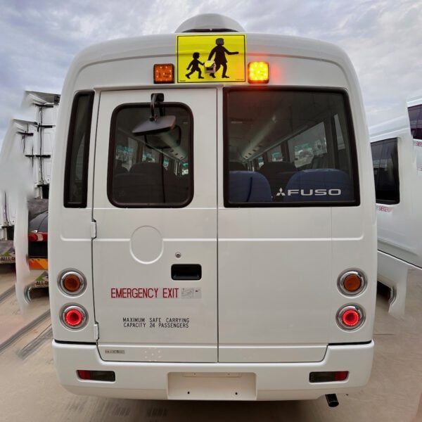 Photo of the rear of a 2024 5th generation BE7 Mitsubishi Rosa bus with Safebus SB001B window mount Victorian school bus lights and mother & child sign installed