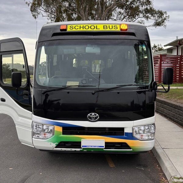 Photo of the front of a 2024 4th generation B80 Toyota Coaster bus with Safebus SB001A surface mount Victorian school bus lights and signage installed
