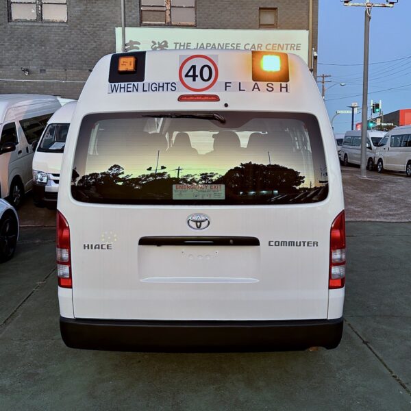 Photo of the rear of a 2014 5th generation Toyota HiAce Commuter bus with Safebus interior mount NSW TS-150 school bus lights, Small School Bus 40Km/h and Small When Lights Flash Signage installed