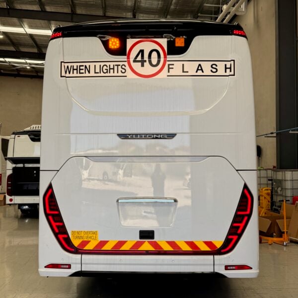 Photo of the rear of a Yutong C12 bus with Safebus SB001A surface mount school bus lights and NSW TS150 signage installed