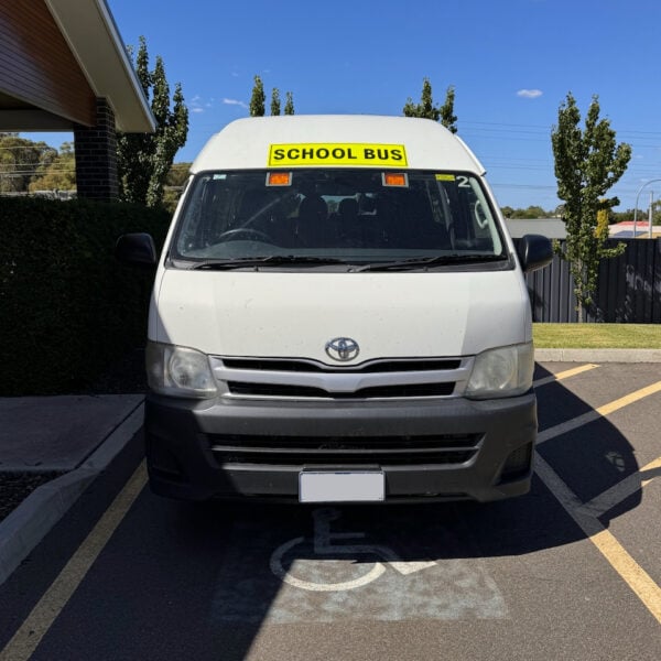 Photo of the front of a 2013 6th generation Toyota HiAce Commuter bus with Safebus interior mount Victorian school bus lights and signage installed