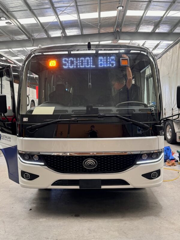 Photo of the front of a 2024 Yutong D7 bus with Safebus window mount school bus lights