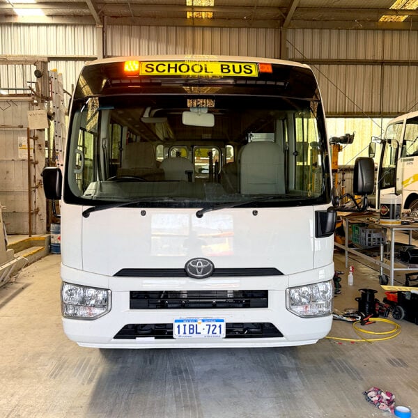 Photo of the rear of a 2024 4th generation B80 Toyota Coaster bus with Safebus SB001A surface mount Victorian school bus lights and signage installed